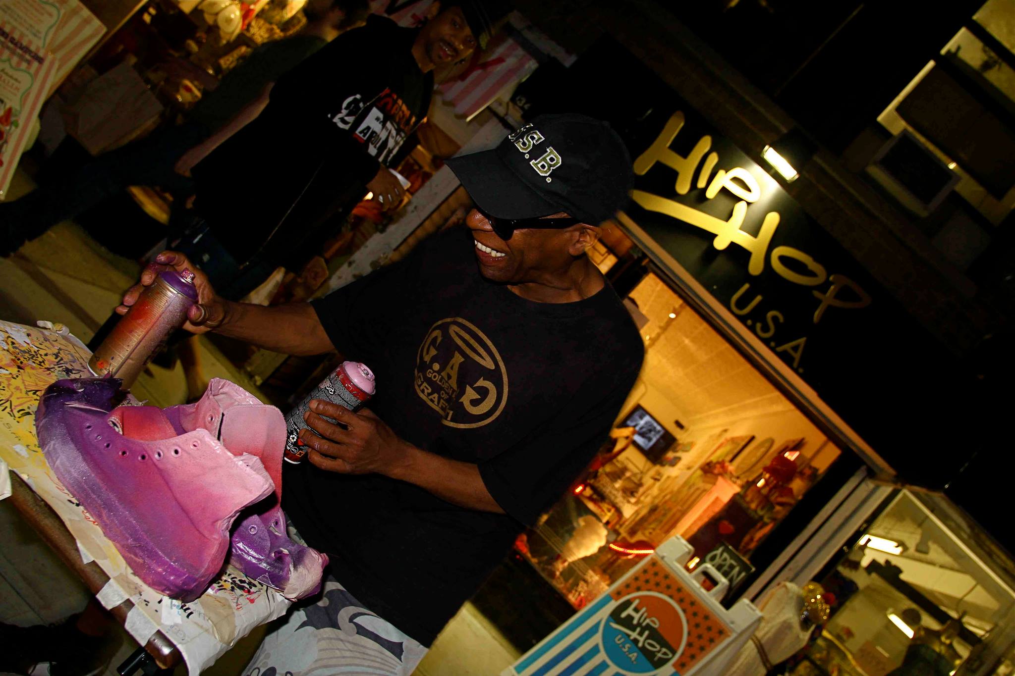 Hip Hop USA store with custom artist, Shadow customizing a sneaker for a shop patron.
